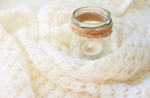 Candle in a jar with a crochet blanket.