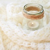Candle in a jar with a crochet blanket.