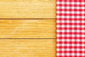 Checkered Tablecloth On The Brown Wooden Background.