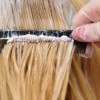 Woman having dye come through her blond hair
