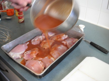 pouring sauce over chicken
