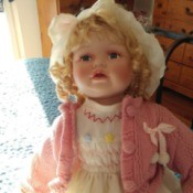 Maker and Value of a Porcelain Doll - blond doll wearing a pink sweater