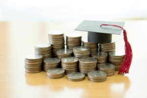 Graduation hat on top of a pile of coins.