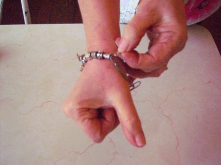 Hooking a bracelet closed by using a paper clip.