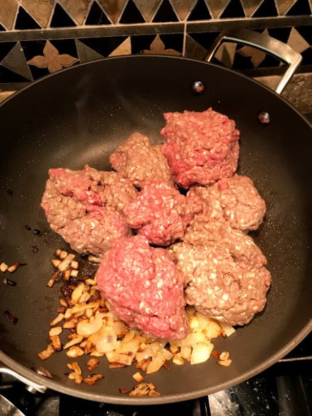 raw ground beef added to browned onions