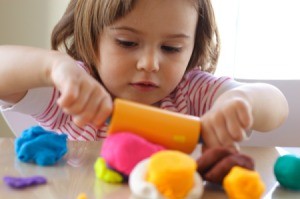 Child playing with many colors of Playdough