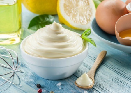 Homemade Mayonnaise with ingredients on a wooden table