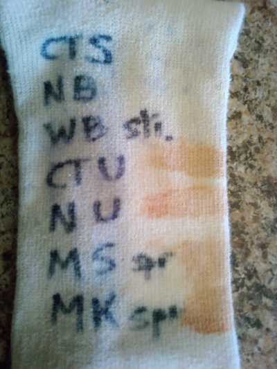 A sock with different sunscreen stains marked with cleaning options.