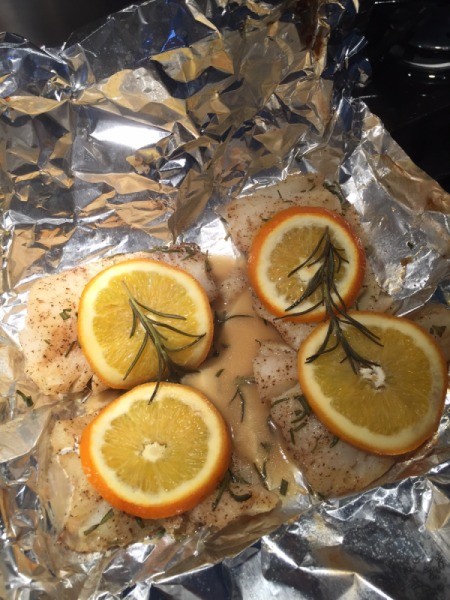 Cod on foil with orange slices and rosemary