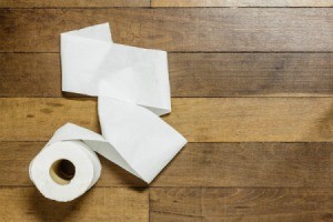 Toilet paper on a wood floor.