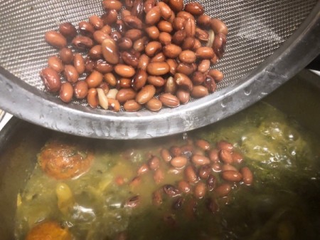 adding drained beans to pot