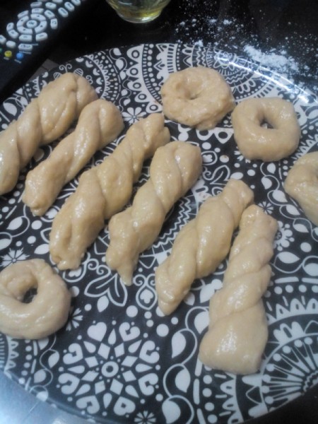 Twisted dough and donuts on plate