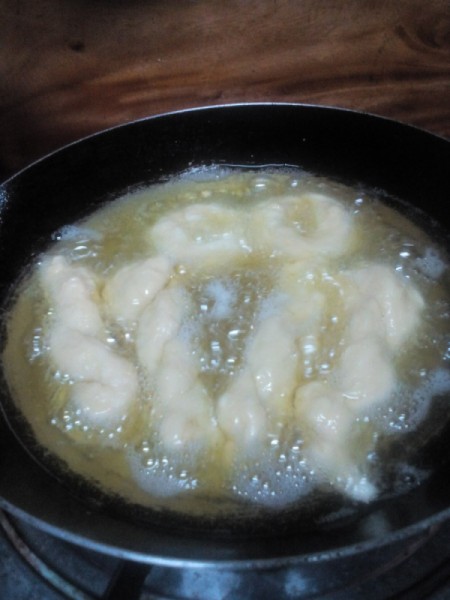 Twisted Donuts cooking in hot oil