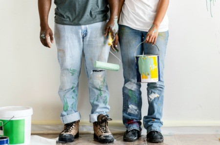 Two people with paint stains on their jeans.