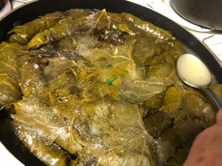 spooning water from Stuffed Grape Leaves (Dolmeh)