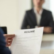 Man sitting down to interview looking at resume
