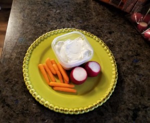 A plate of ranch dip with vegetables.