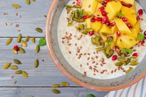 Tasty and healthy oatmeal porridge with mango, pomegranate and seeds.