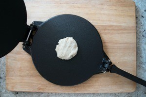 Ball of dough on a tortilla press.