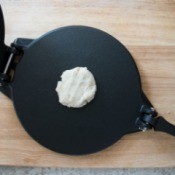 Ball of dough on a tortilla press.