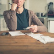 Woman sitting in kitchen working on her budgeting