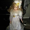 Value of a Porcelain Doll - doll wearing a white satin dress and hat