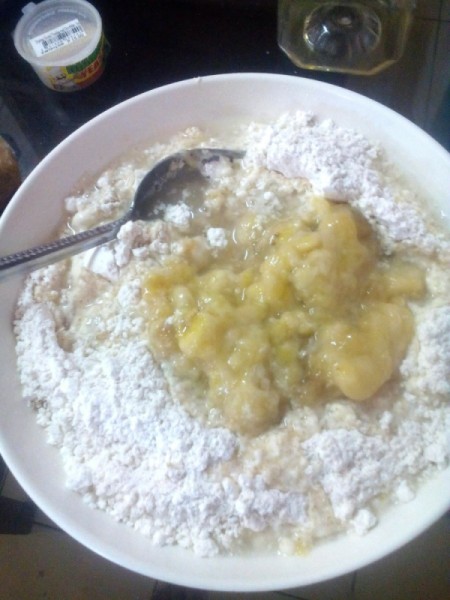 adding banana to flour sugar mixture