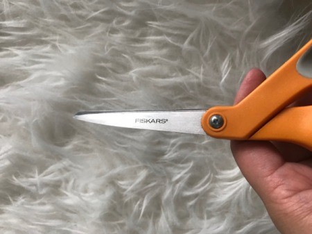 A pair of orange handled scissors.