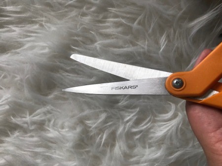 A pair of orange handled scissors.