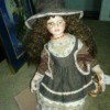 Value of a Camille Porcelain Doll - doll wearing a hat and pinafore dress