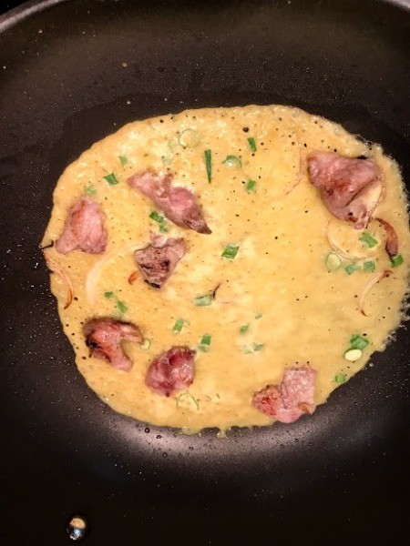 crepe batter added to pork and onion