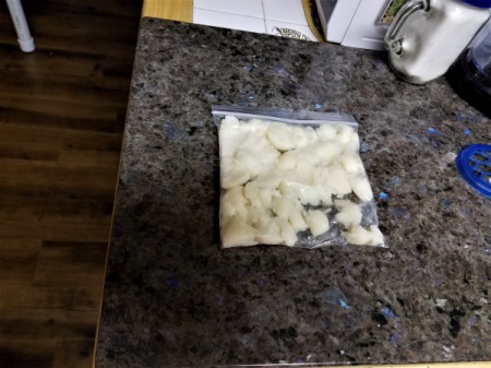 Pieces of potato that have been squished in a plastic ziptop bag.