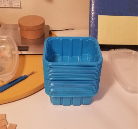 A stack of blue plastic mushroom tubs.