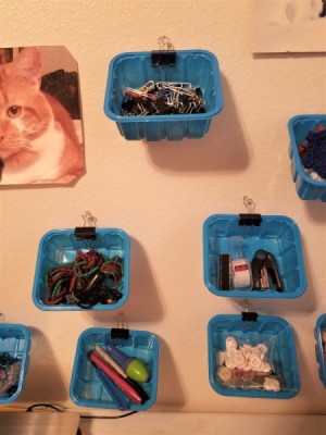 Several mushroom tubs on a wall containing different craft supplies.