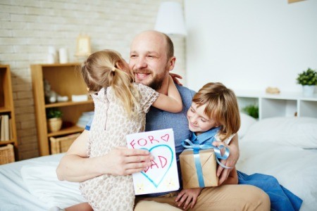 Girls giving happy dad father's day gift and card