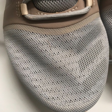 A small stain on the toe of a pair of sneakers