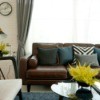 Brown leather sofa with throw pillows.