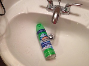 A bottle of scrubbing bubbles inside a bathroom sink.