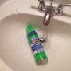 A bottle of scrubbing bubbles inside a bathroom sink.