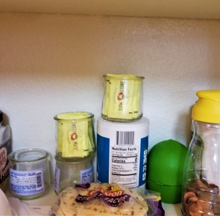 Two filled jars of Splenda packets in the pantry.