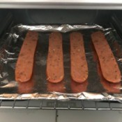 Two hot dogs that have been cut in half and then broiled.
