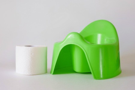 Green plastic potty chair, with a roll of toilet paper.