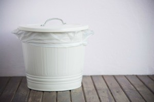 Small white metal garbage can with a lid.