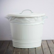 Small white metal garbage can with a lid.