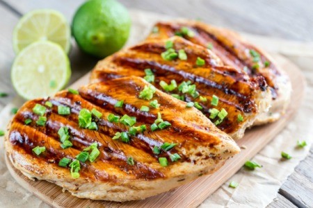 Grilled Chicken on a cutting board with limes.