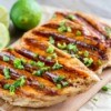 Grilled Chicken on a cutting board with limes.