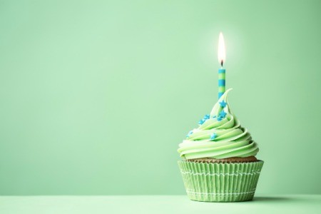 Green cupcake with a blue and green candle.