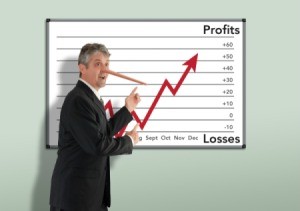 Businessman with Pinocchio nose pointing at a profit loss chart that is going up.