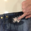 Salt and vinegar being used to treat a rust stain on overalls.