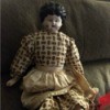 Identifying an Antique Porcelain Doll  - doll with molded hair wearing a tan and brown print dress and tan apron